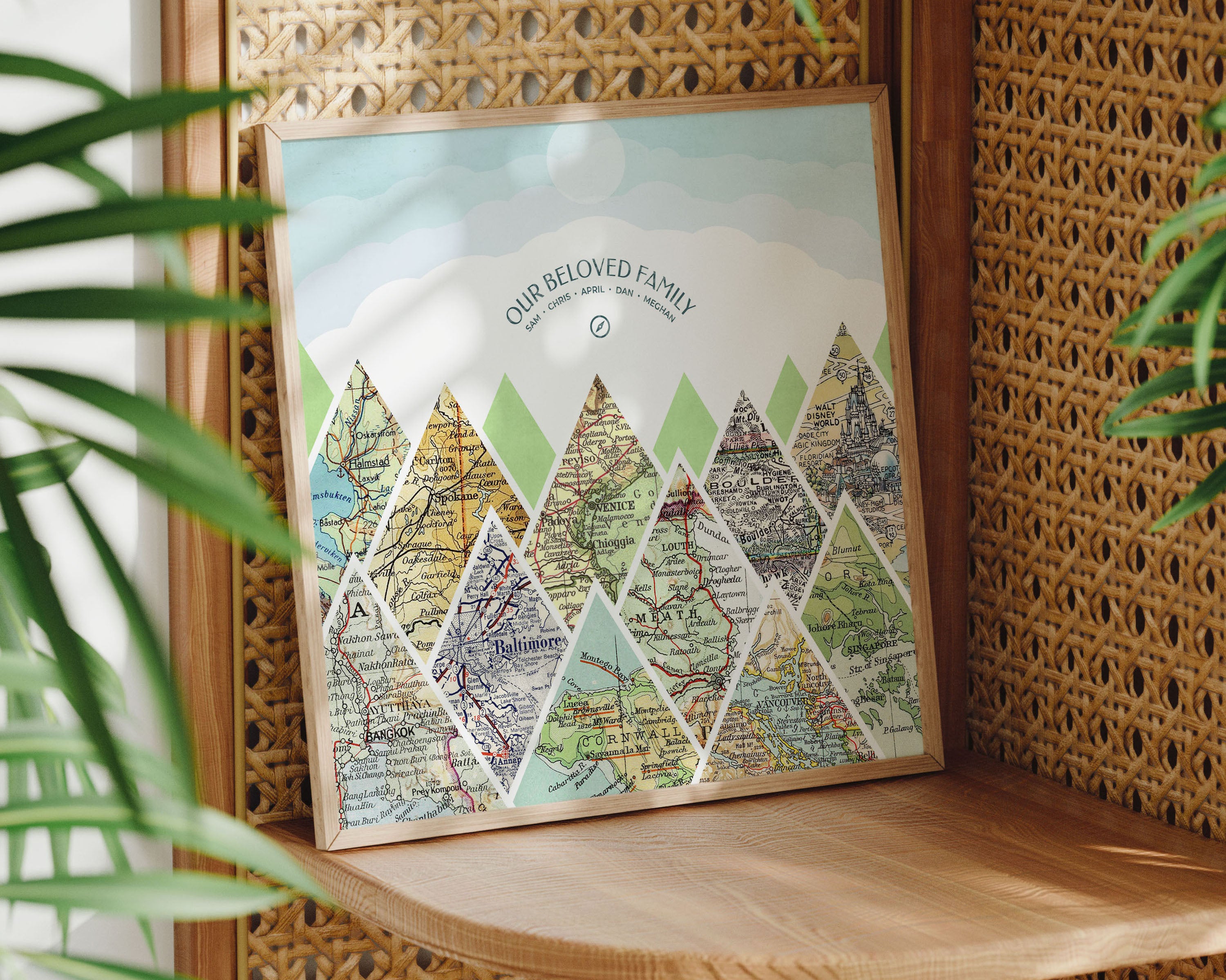 Mountain scape relief with inset maps in a square. Geometric clouds above. Sitting on shelf in thin wood frame.