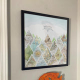[Black Frame|18x18|16 Maps] Mountain scape relief with inset maps and geometric clouds above. Hanging in customer's home.