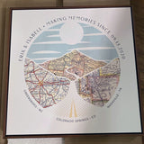 [Walnut Canvas|24x24|3 Maps] Relief of hills and highway into the horizon, with inset maps. Sitting flat on a table.