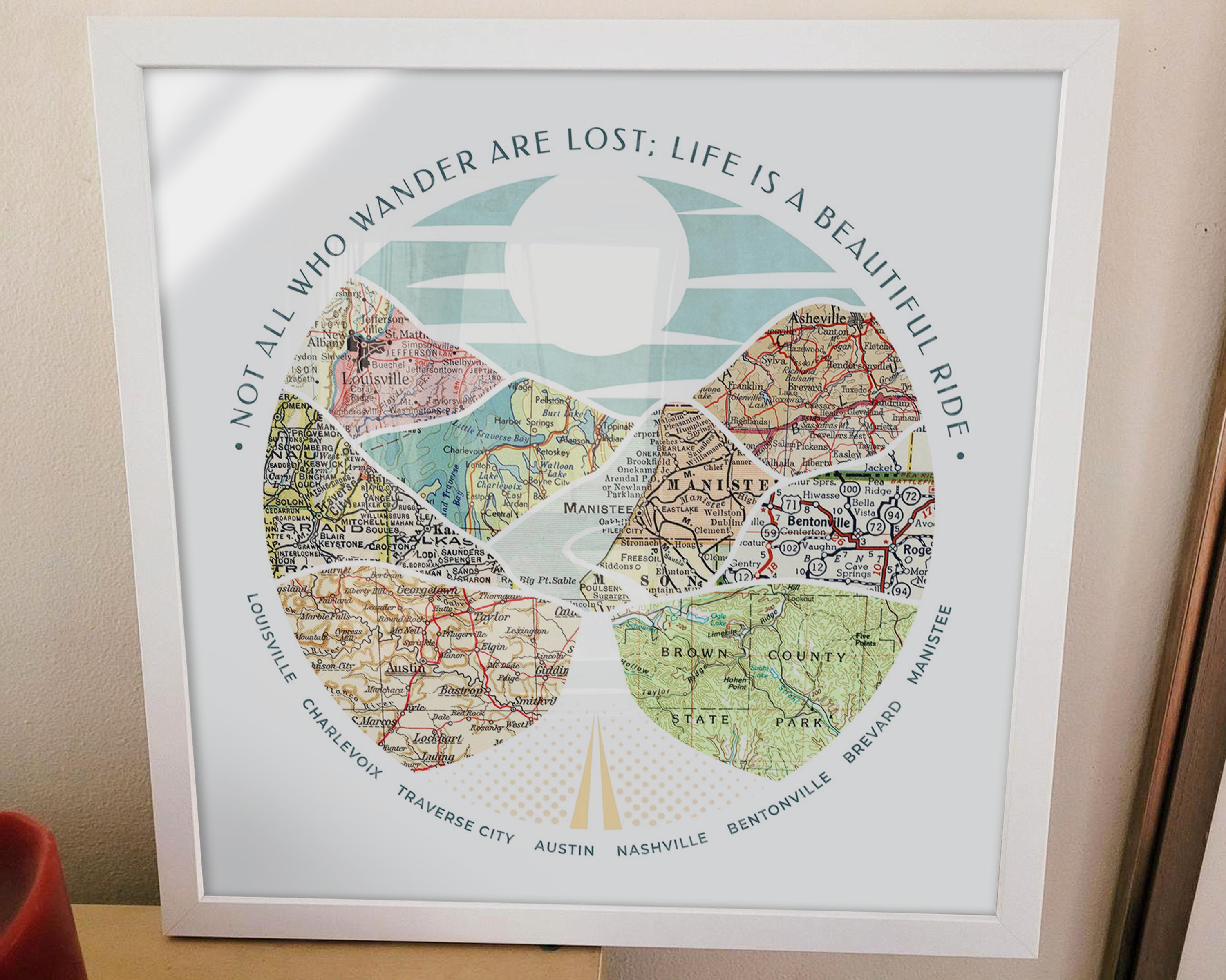 [White Frame|16x16|8 Maps] Relief of hills and highway into the horizon, with inset maps. Sitting on a table.