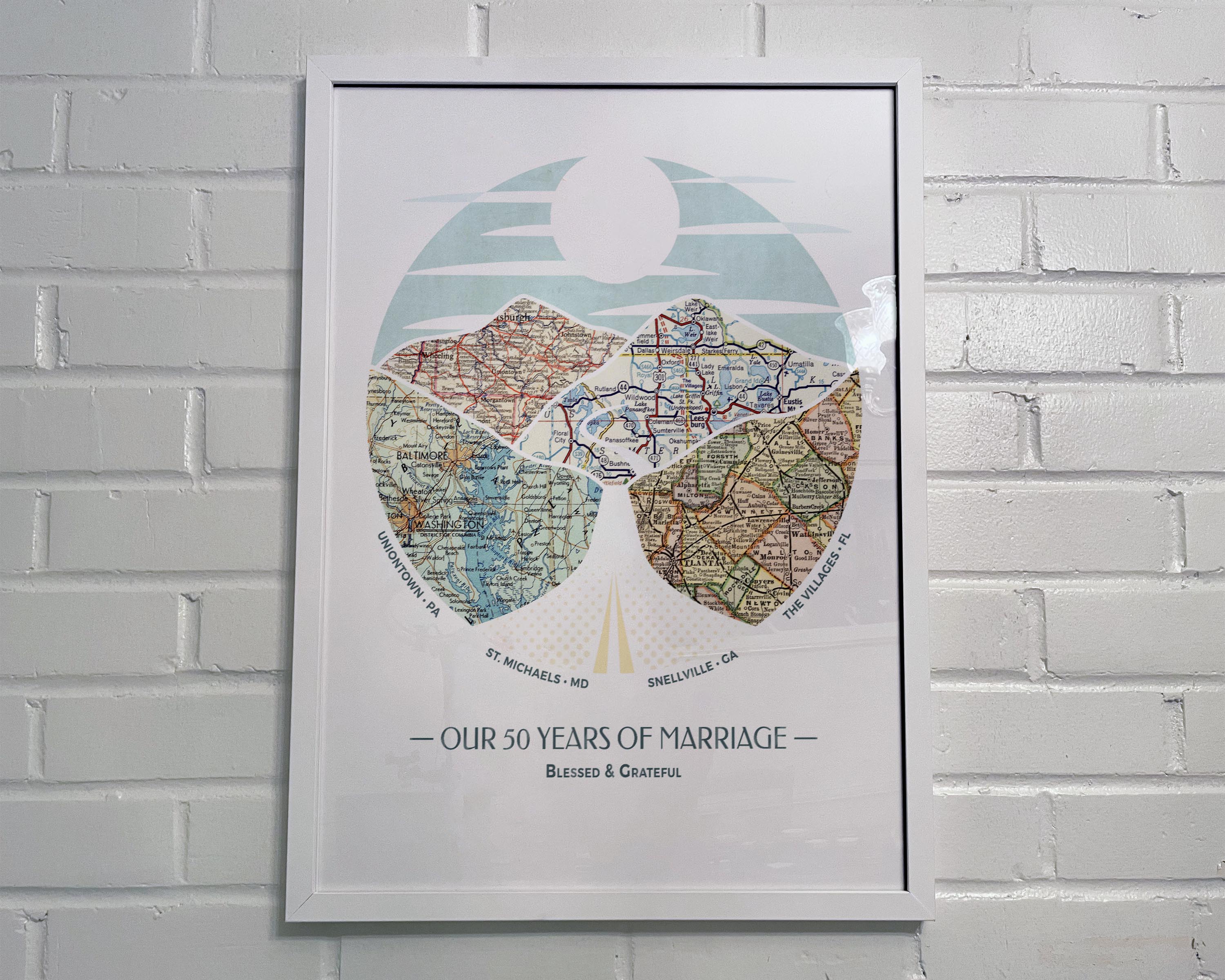 [White Frame|18x24|4 Maps] Relief of hills and highway into the horizon, with inset maps. On white brick wall