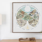 wanderlust roadtrip map print seven maps wood frame. Relief of hills and highway into the horizon, with inset maps. Hanging over a table with log on it.